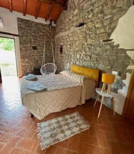 a bedroom with a bed and a stone wall at Masseria dell'oltrepo' in Buschi