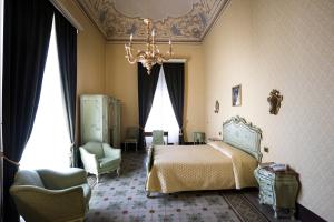 a bedroom with a bed and a chandelier at Palazzo Failla Hotel in Modica