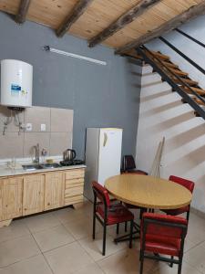 a kitchen with a table and chairs and a refrigerator at Hostel Sol in Santa Fe +3 photos