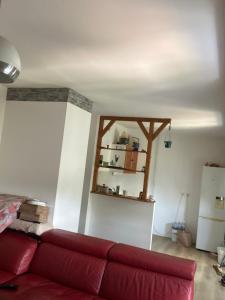 Una sala de estar con un sofá rojo y un espejo. en Studio 30m2, en Thorigny-sur-Marne