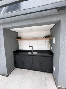 a kitchen with a sink in a garage at Loft 413 Inn no Parque Una in Pelotas