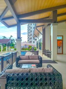 a patio with a couch and a table on a balcony at Kuya Os Staycation at Royal Oceancrest Condominium Panglao in Dauis