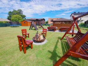 a playground with chairs and a fire pit in a yard at Willa Barbara in Tupadła