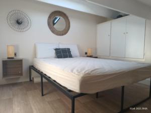 Appartement les flots bleues في فالراس بلاج: سرير كبير في غرفة نوم مع مرآة