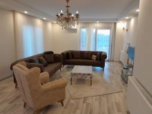 una sala de estar con un sofá y dos sillas en Doğan Suite, en Trabzon