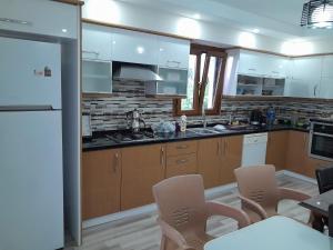Una cocina con electrodomésticos blancos y gabinetes marrones. en Doğan Suite, en Trabzon