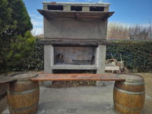 a stone fireplace with a bench on two barrels at El descanso, zona de bodegas in Ciudad Lujan de Cuyo