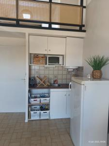 Appartement les flots bleues في فالراس بلاج: مطبخ مع دواليب بيضاء وميكرويف +21 صورة