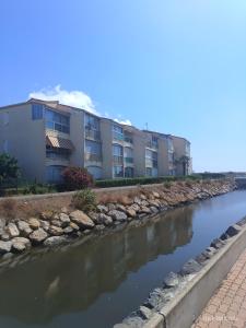 Appartement les flots bleues في فالراس بلاج: صف من مباني الشقق بجانب نهر