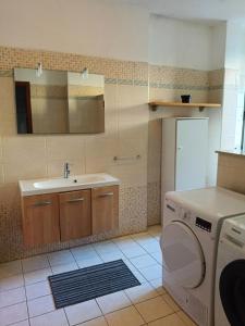 a bathroom with a sink and a washing machine at Casa vacanze Anna a due passi da Otranto in Uggiano la Chiesa +11 photos