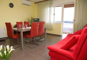 a living room with a table and a red couch at Apartment Boni in Šibenik
