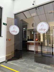 a store window with two white signs on the front at Hotel Village Campinas in Campinas