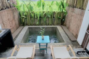 a small pool of water with two chairs and a table at Kaia Siargao Villas in General Luna