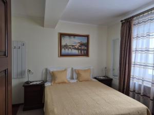 a bedroom with a bed and a picture on the wall at Pensiunea Select in Curtea de Argeş