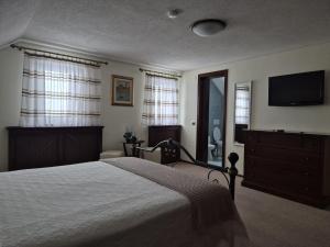 a bedroom with a bed and a flat screen tv at Pensiunea Select in Curtea de Argeş