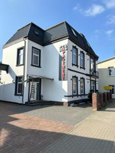 平讷贝格Dias Apartment的一座黑色屋顶的白色建筑