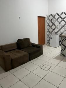 a living room with a brown couch in a room at Casa simples e conforto in Belém