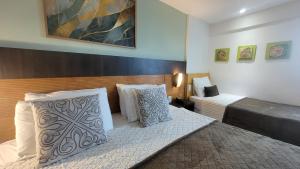 a hotel room with two beds in a room at NATAL PLAZA PONTA NEGRA in Natal