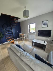 a living room with a couch and a book shelf at Beachwood Cottage in Spiddal in Galway