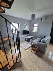 a living room with a couch and a table at Beachwood Cottage in Spiddal in Galway