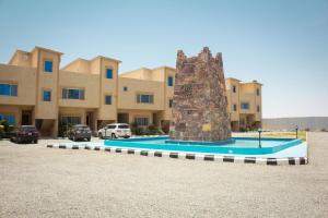 a building with a monument in front of it at فوج فيو للفلل والشقق الفندقية in Al Namas