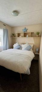 a bedroom with a large bed with a blue star above it at Seascape Holiday Caravan in Tunstall
