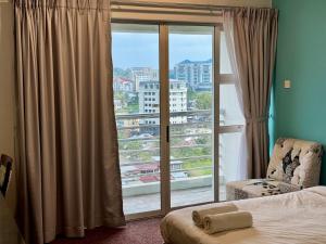 a bedroom with a window with a view of a city at Deluxe Room for 2 Pax - Central of Kuching in Kuching