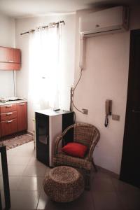 a living room with a chair and a phone at La Casetta di Ele in Sassari