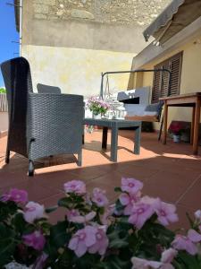 a patio with a table and a bench and flowers at La Casetta di Ele in Sassari