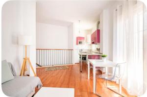a living room with a table and a kitchen at Apartamento luminoso en Espartinas Totalmente climatizado in Espartinas