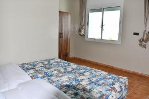 a bedroom with a bed and a window at Residence Zomroda Sidi Bouzid in Sidi Bouzid