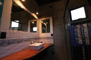 a bathroom with a sink and two mirrors at Casa Arte Flor in São Bento do Sapucaí