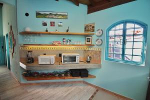 a kitchen with a counter with two microwaves and a window at Casa Arte Flor in São Bento do Sapucaí +22 photos