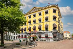 海牙Hotel Des Indes The Hague的一座黄色的大楼，周围有