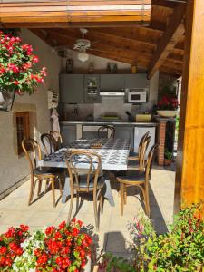 a patio with a table and chairs and a kitchen at Le clos fleuri in Saint-Gervazy