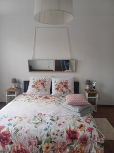 un letto con copriletto e cuscini floreali; di Zacisze Pod Nikiszem a Katowice