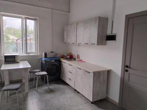 a small kitchen with a sink and a stove at Aerodrom Hotel - Hostel in Almaty