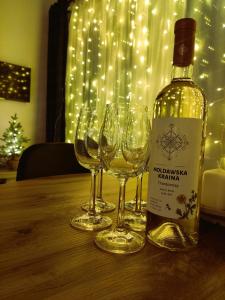 a bottle of wine sitting on a table with wine glasses at Ptasi Śpiew in Grzędy +5 photos