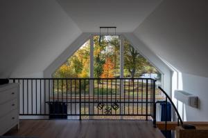 an attic room with a large window and a balcony at Ptasi Śpiew in Grzędy