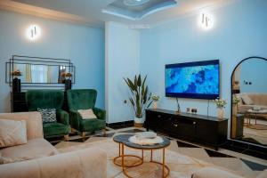 a living room with a couch and a flat screen tv at Michelle's Apartments in Kigoma