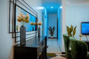 a living room with a black desk and a chair at Michelle's Apartments in Kigoma