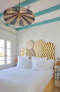 a bedroom with a white bed with blue and yellow stripes at Hotel Misiana Tarifa in Tarifa