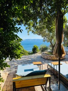a patio with an umbrella and a bench and a pool at Die Appartements Glavas mit Loggia und Balkon für 3 Personen in Novi Vinodolski