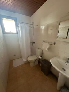 Un baño blanco con inodoro y lavabo. en T3 à 100m de la plage, au calme, Saint-Florent, en Saint-Florent