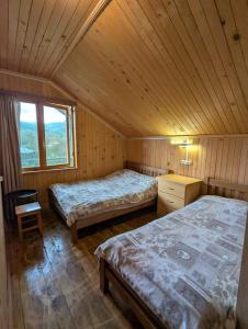 NikortsmindaGuest house in Nikortsminda Racha的小木屋内一间卧室,配有两张床