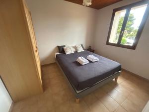 Un dormitorio con una cama con dos toallas encima. en T3 à 100m de la plage, au calme, Saint-Florent, en Saint-Florent