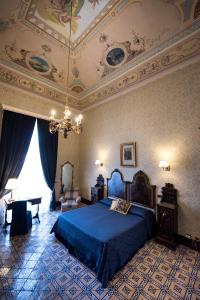 a bedroom with a blue bed and a ceiling at Palazzo Failla Hotel in Modica