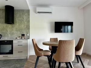 a kitchen with a table and chairs in a room at Verde Klon Apartment- Lotnisko Jasionka in Jasionka