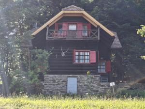 a large wooden house with a balcony on top at Waldpoesie - Das Wald-Cottage in Benking +18 photos