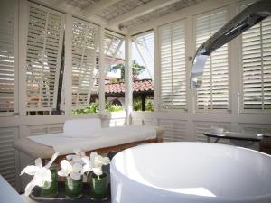 a bathroom with a tub and a table and windows at California Park Hotel in Forte dei Marmi